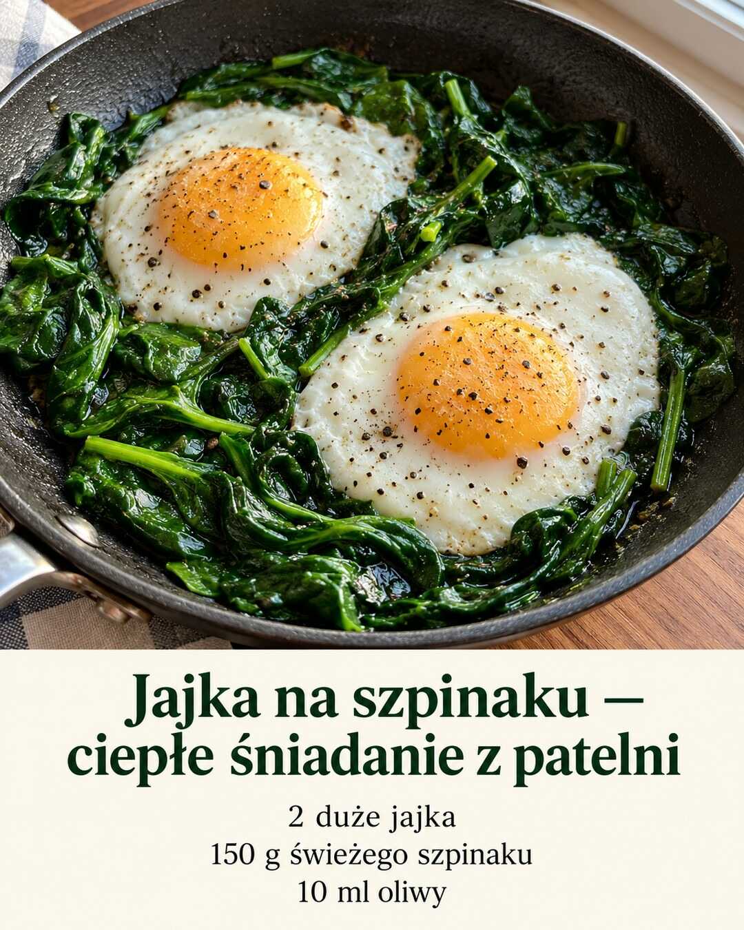 Dwa ścięte jajka sadzone na zielonych liściach szpinaku w niewielkiej patelni.