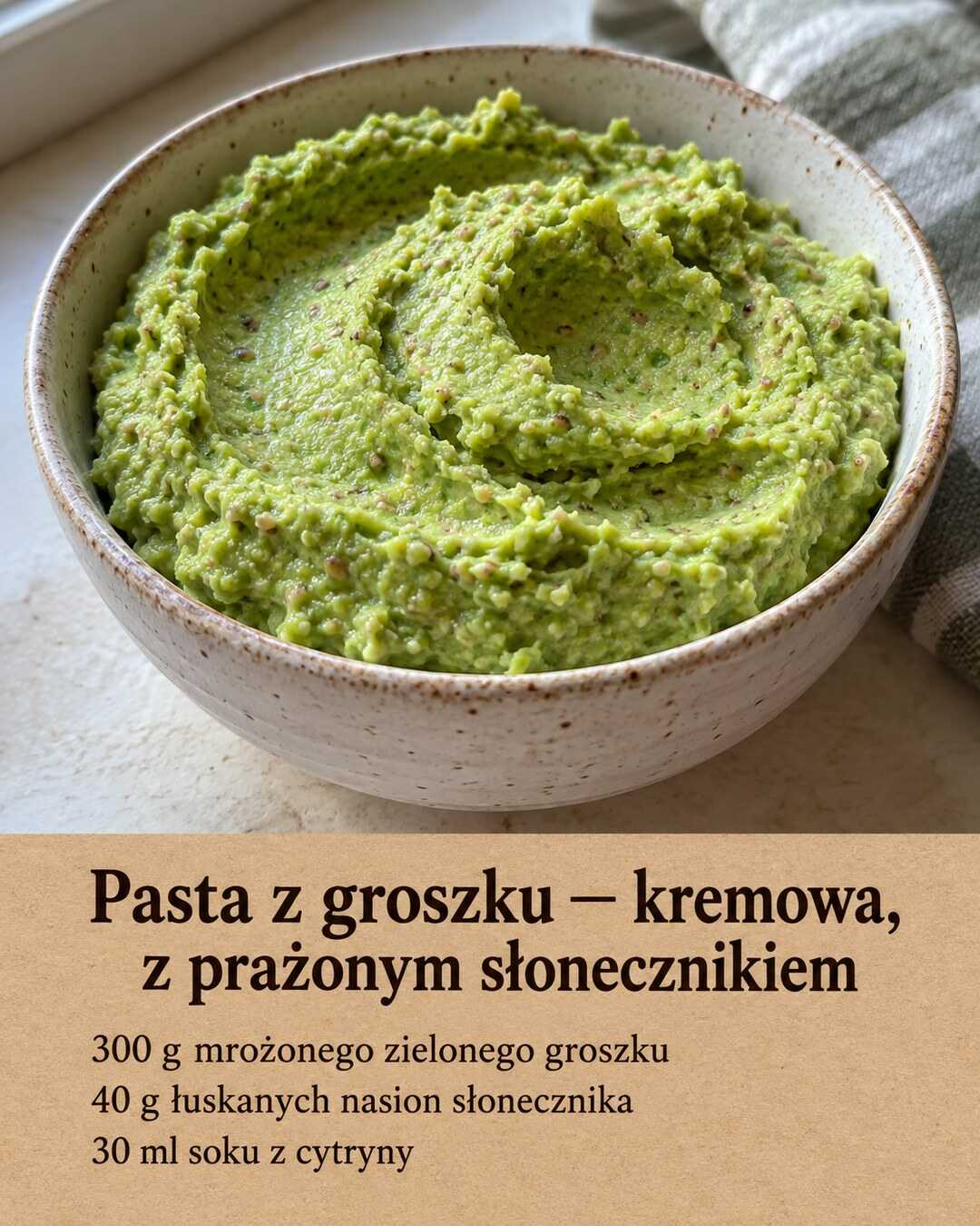 Zielona pasta z groszku w miseczce, z drobnymi ziarenkami słonecznika widocznymi w kremie.